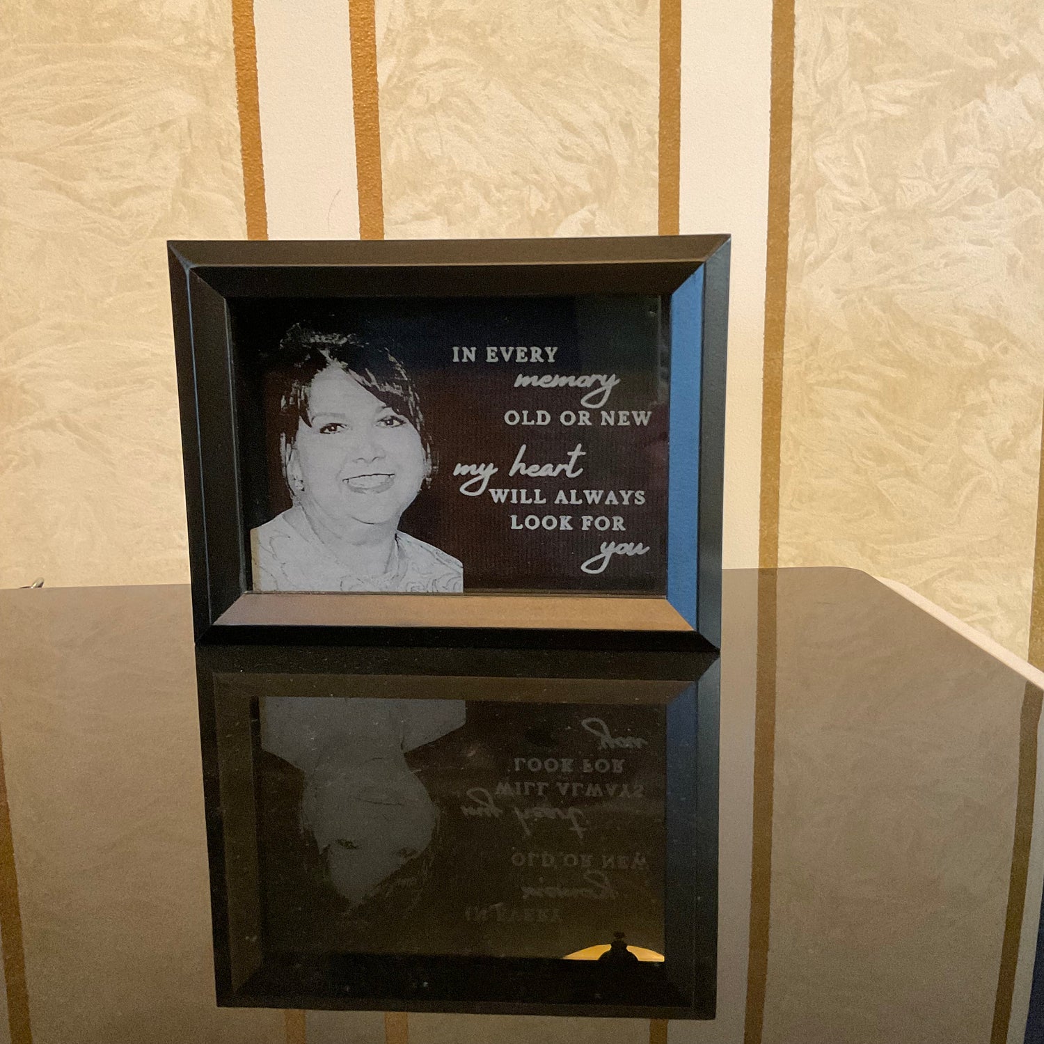 black shadow box frame with photograph and phrase etched into the glass